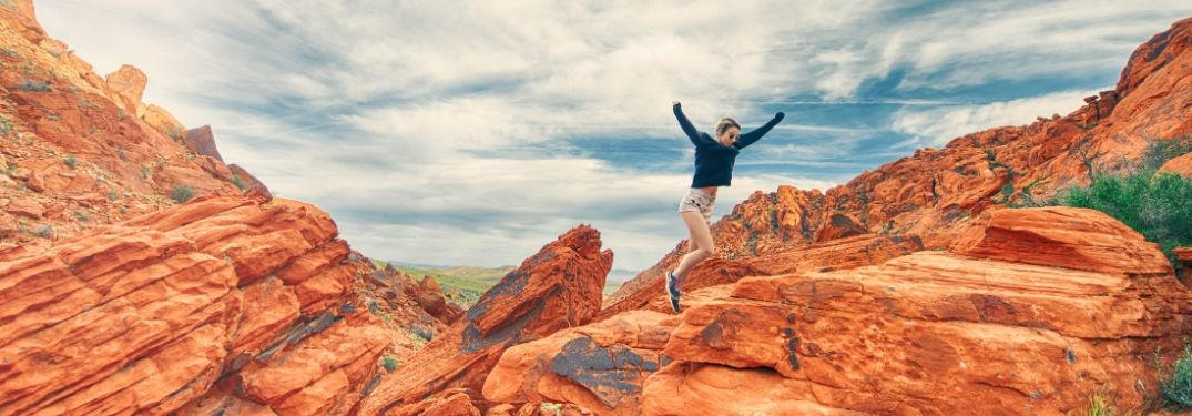 Woman Hiking on Rocks in a Desert