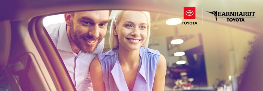 Couple Looking in Window of a New Car with Earnhardt Toyota Logo in Upper Right