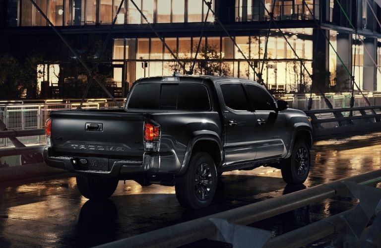 Black 2021 Toyota Tacoma Nightshade Edition Rear Exterior on City Street at Night