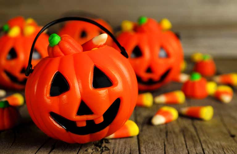 Orange Jack-o-Lantern Buckets on a Table with Candy Corn