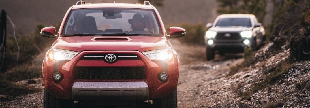 Red 2021 Toyota 4Runner and Gray 2021 Toyota Tacoma on a Trail