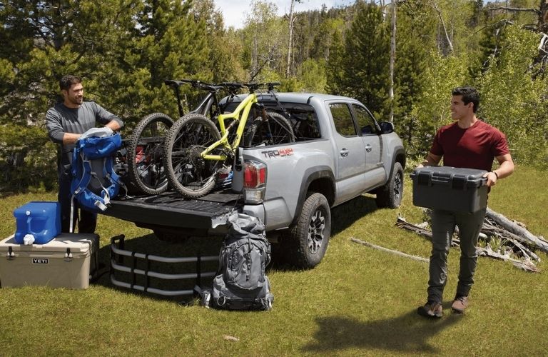 Men By a Gray 2021 Toyota Tacoma with Bikes and Cargo in the Bed