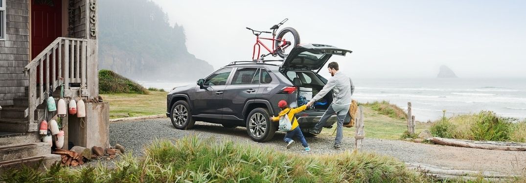 Father and Son Unloading Cargo From Gray 2021 Toyota RAV4