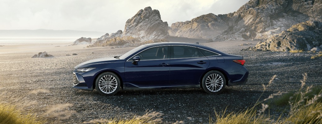 2021 Toyota Avalon blueprint parked on rocky shore with grass in foreground