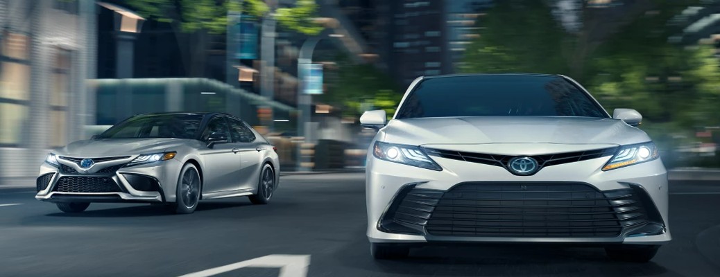 Two recent model Toyotas driving toward the camera on a freeway
