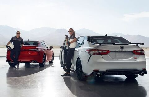 People standing by Toyota cars.